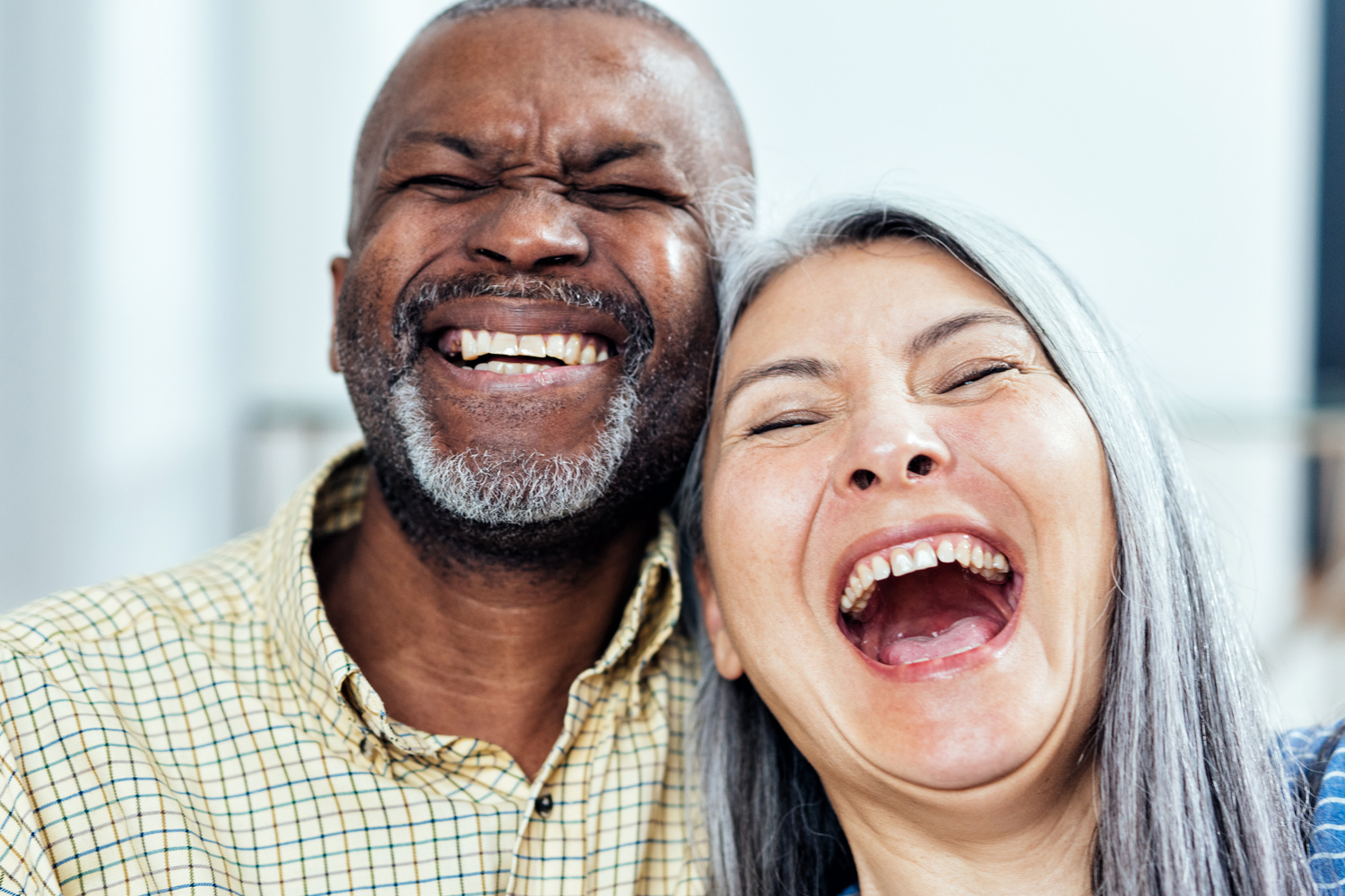 cinematic image of an happy multiethnic senior couple. Indoors Lifestyle moments at home. Concept about seniority and relationships
