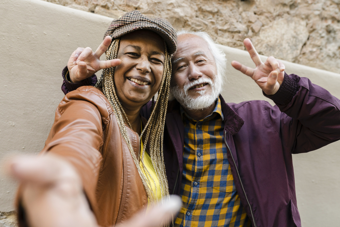 happy senior couple taking photos in the city traveling