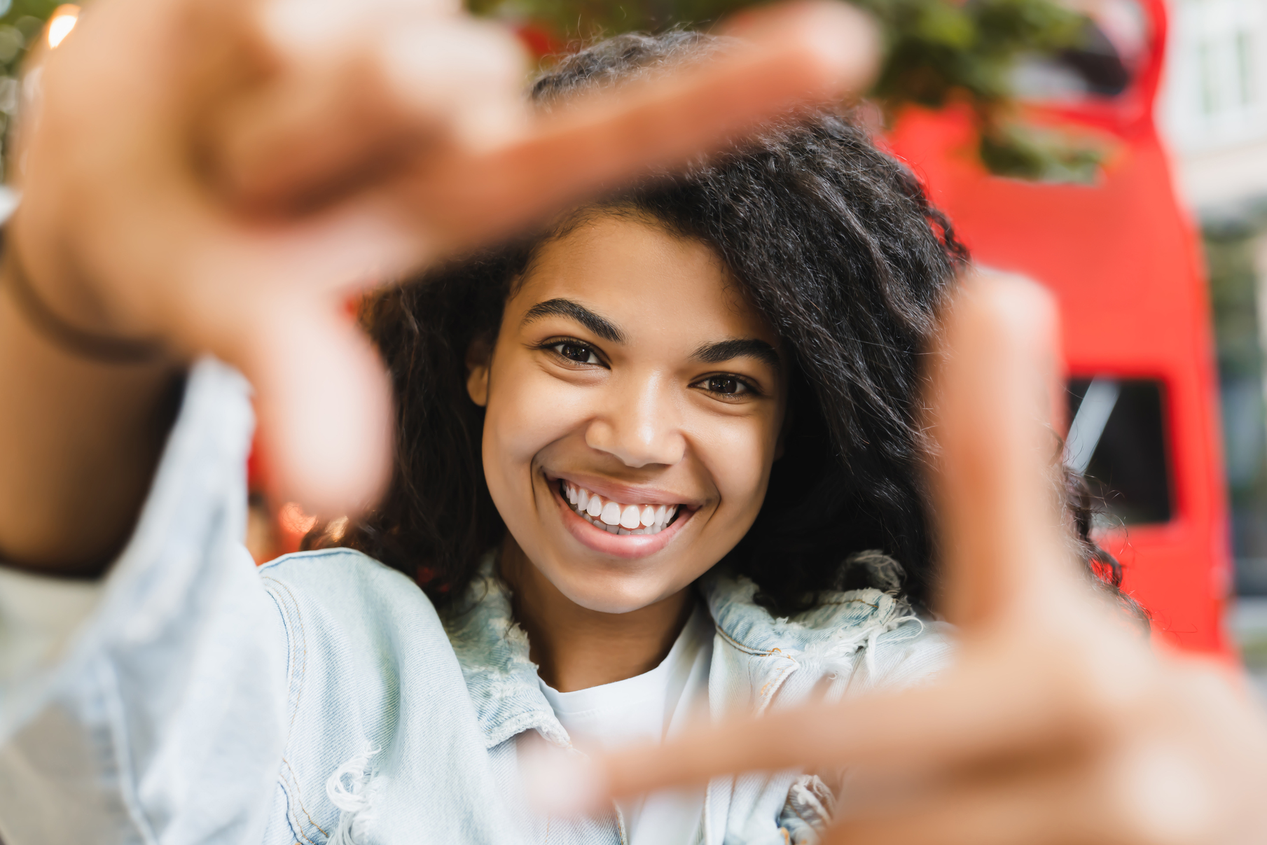Smiling african-american woman young student freelancer taking selfie photo on smart phone with a friend walking in city park.